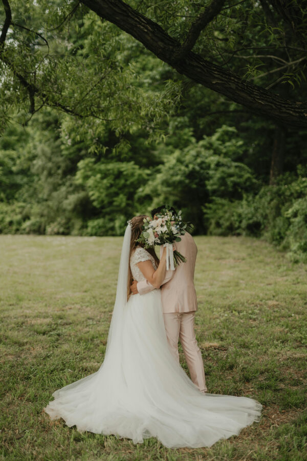 couple kissing behind a bouquet during their destinatio wedding in Jamaica